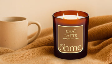 Bougie parfumée artisanale ōhme Chaï Latte, ambiance chaleureuse et naturelle dans un intérieur beige – les senteurs idéales pour chaque pièce de la maison.
